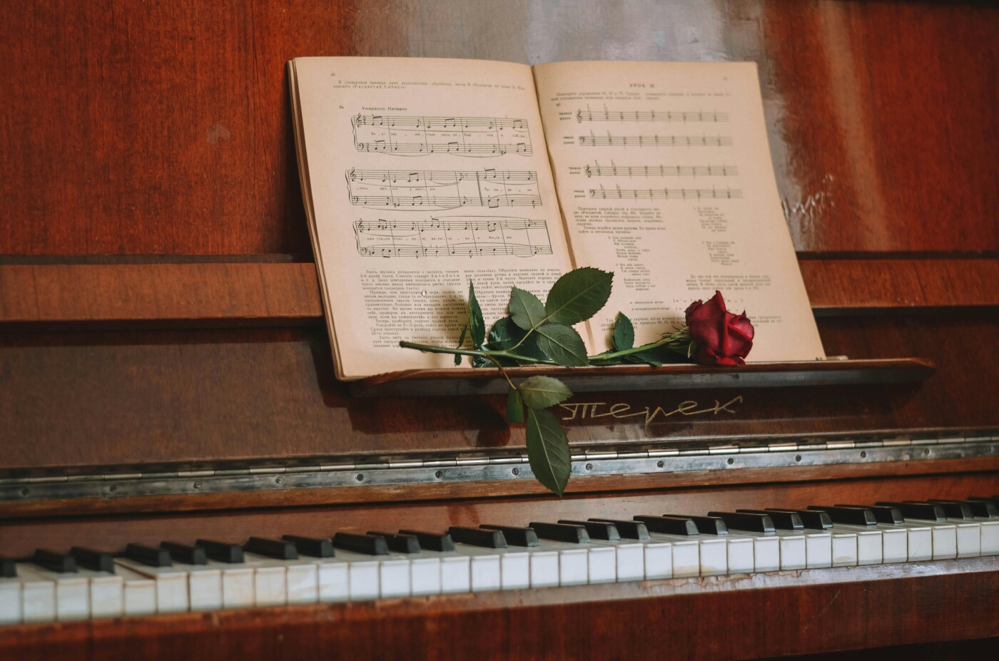 Uitvaart muziek piano met een boekje muziek noten en een rode roos