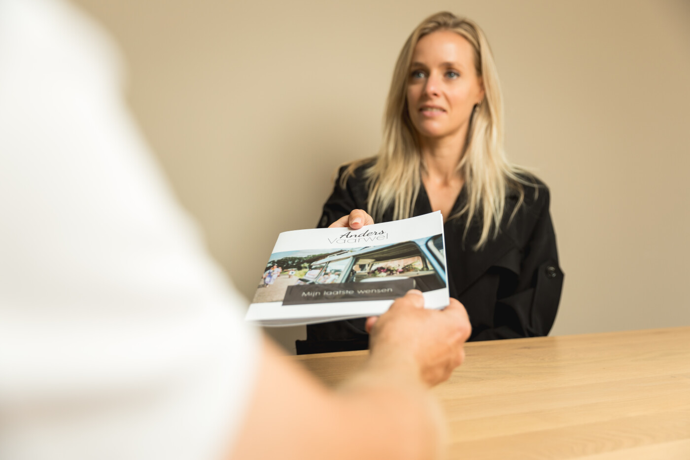 Anders vaarwel blonde vrouw die een boekje aan iemand geeft